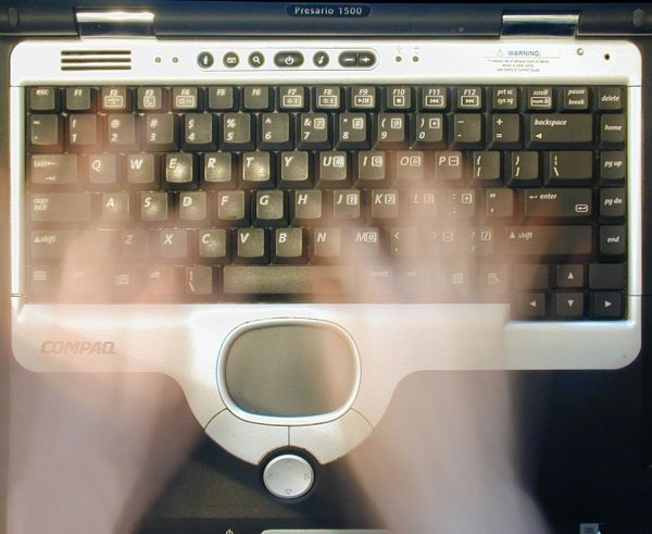 A photo of hands over an old Compaq keyboard, like a ghostwriter. It's supposed to symbolize guest posting.